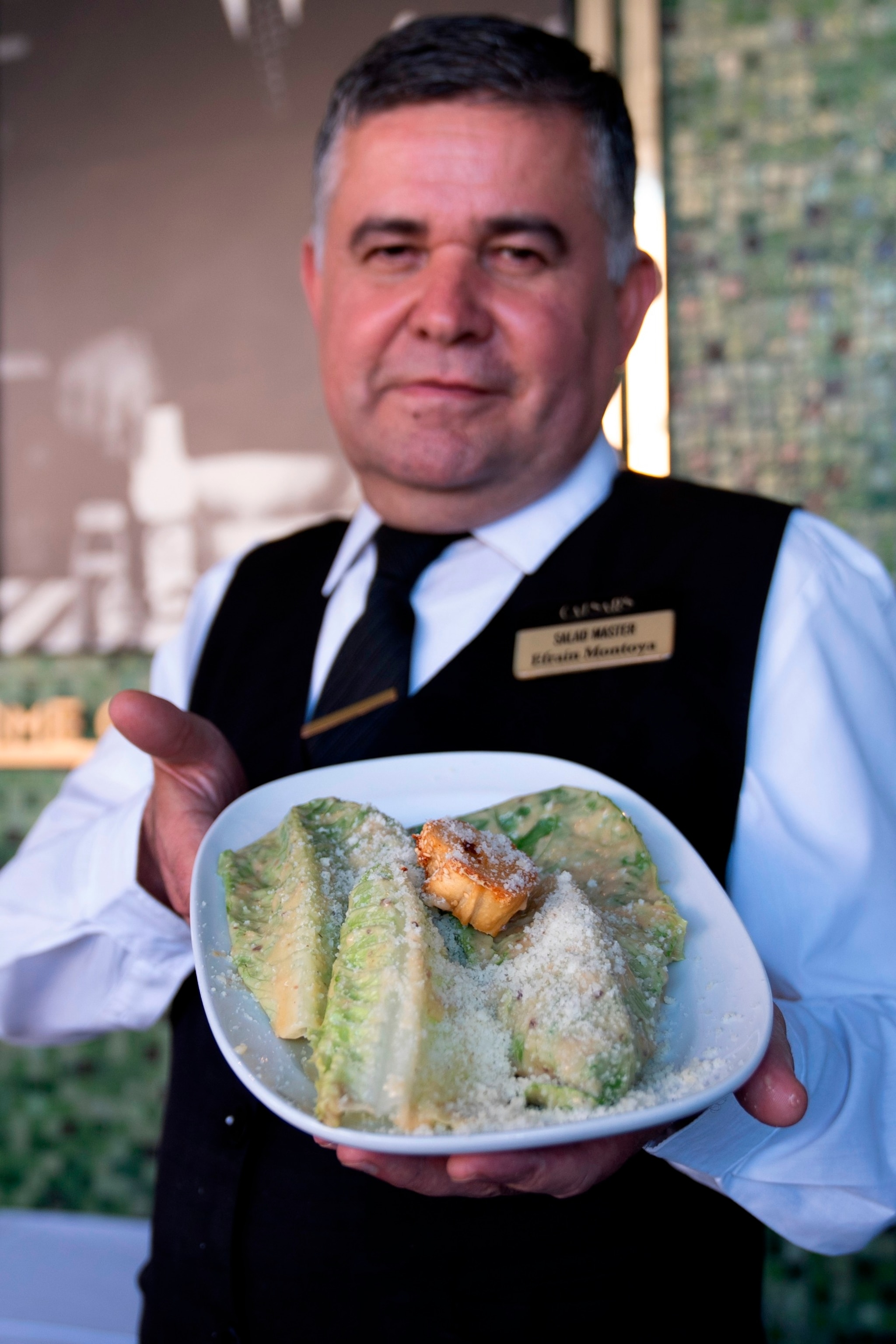 PHOTO: Salad Master Efrain Montoya poses holding a Caesar salad at Ceasar's restaurant, June 27, 2024, in Tijuana, Mexico. 