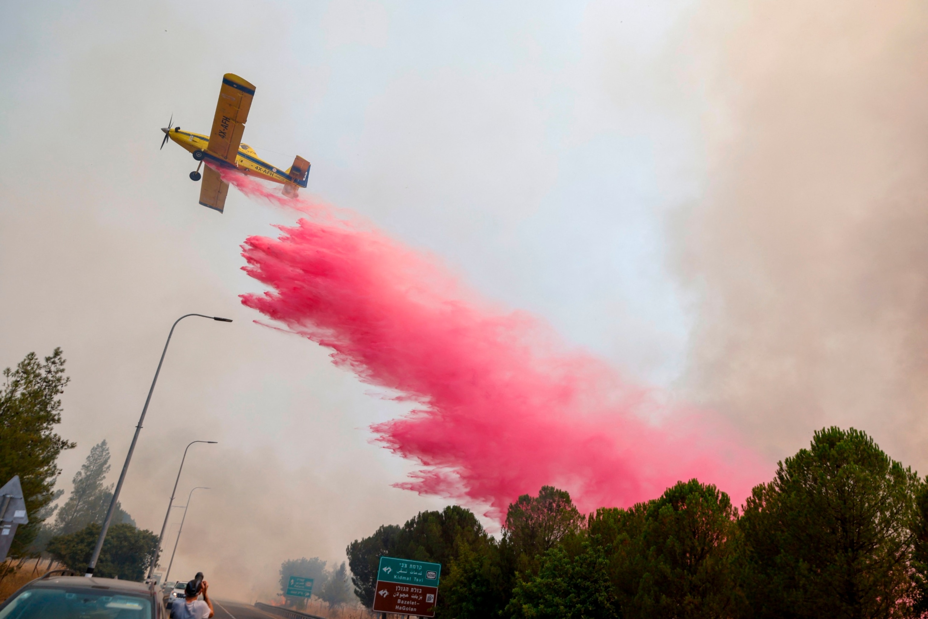 PHOTO: An Israeli firefighter airplane drops flame retardant on fires smoke after rockets launched from southern Lebanon hit areas in northern Israel on July 4, 2024. 