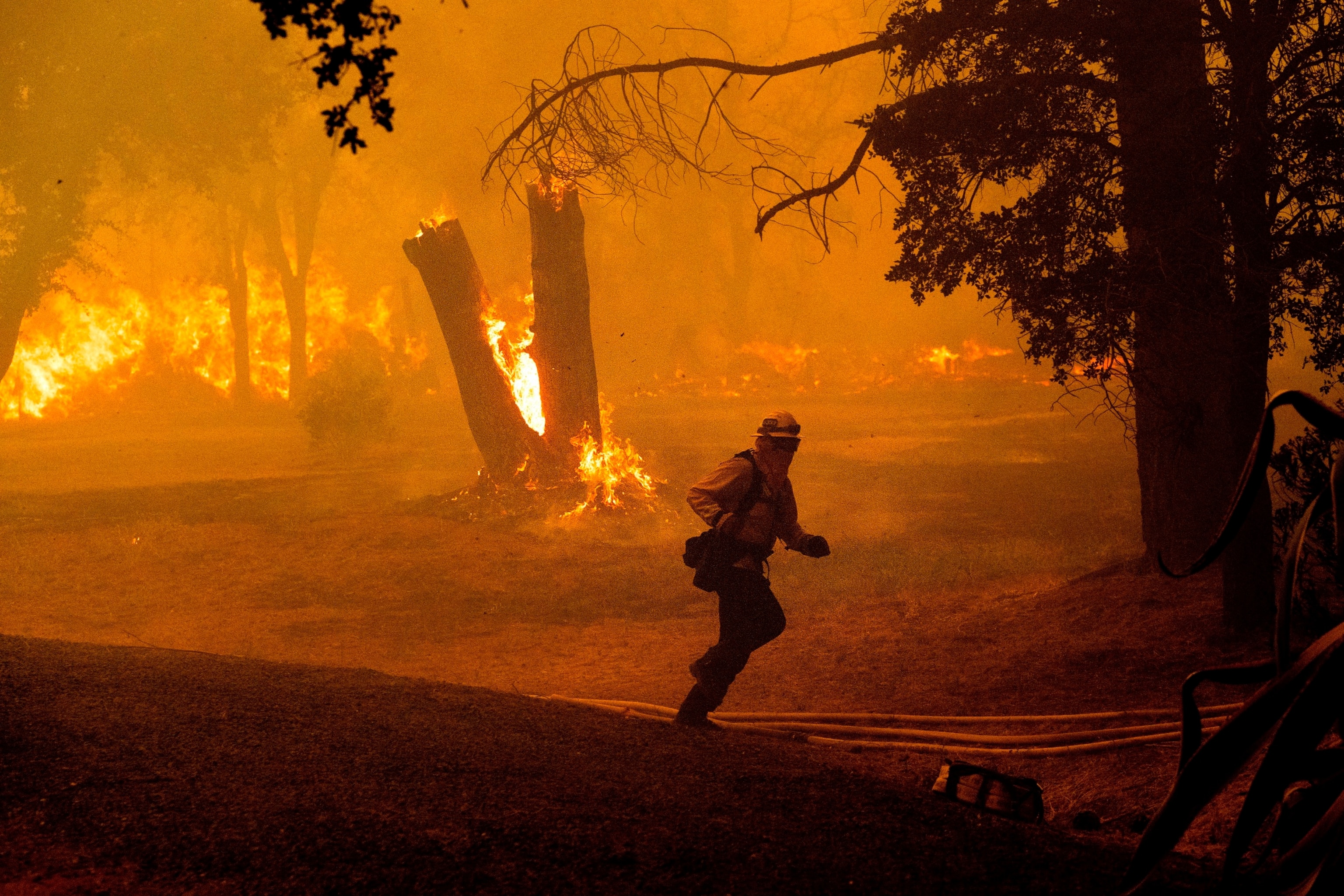 PHOTO: A firefighter runs while battling the Thompson Fire burning in Oroville, Calif., Tuesday, July 2, 2024.