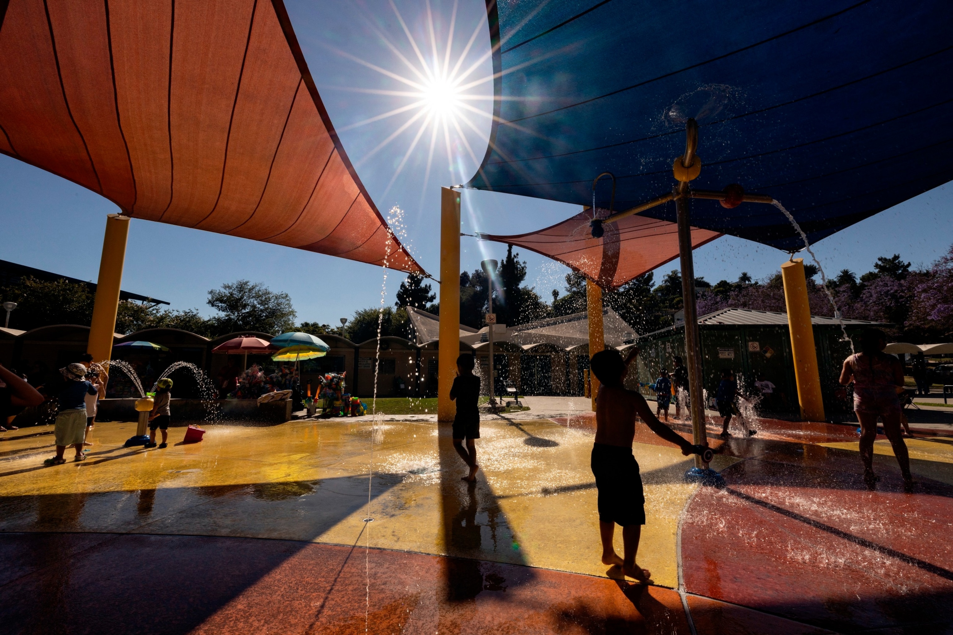 PHOTO: Children play with the water features at a park as southern California faces a heatwave, in Los Angeles, on July 3, 2024. 